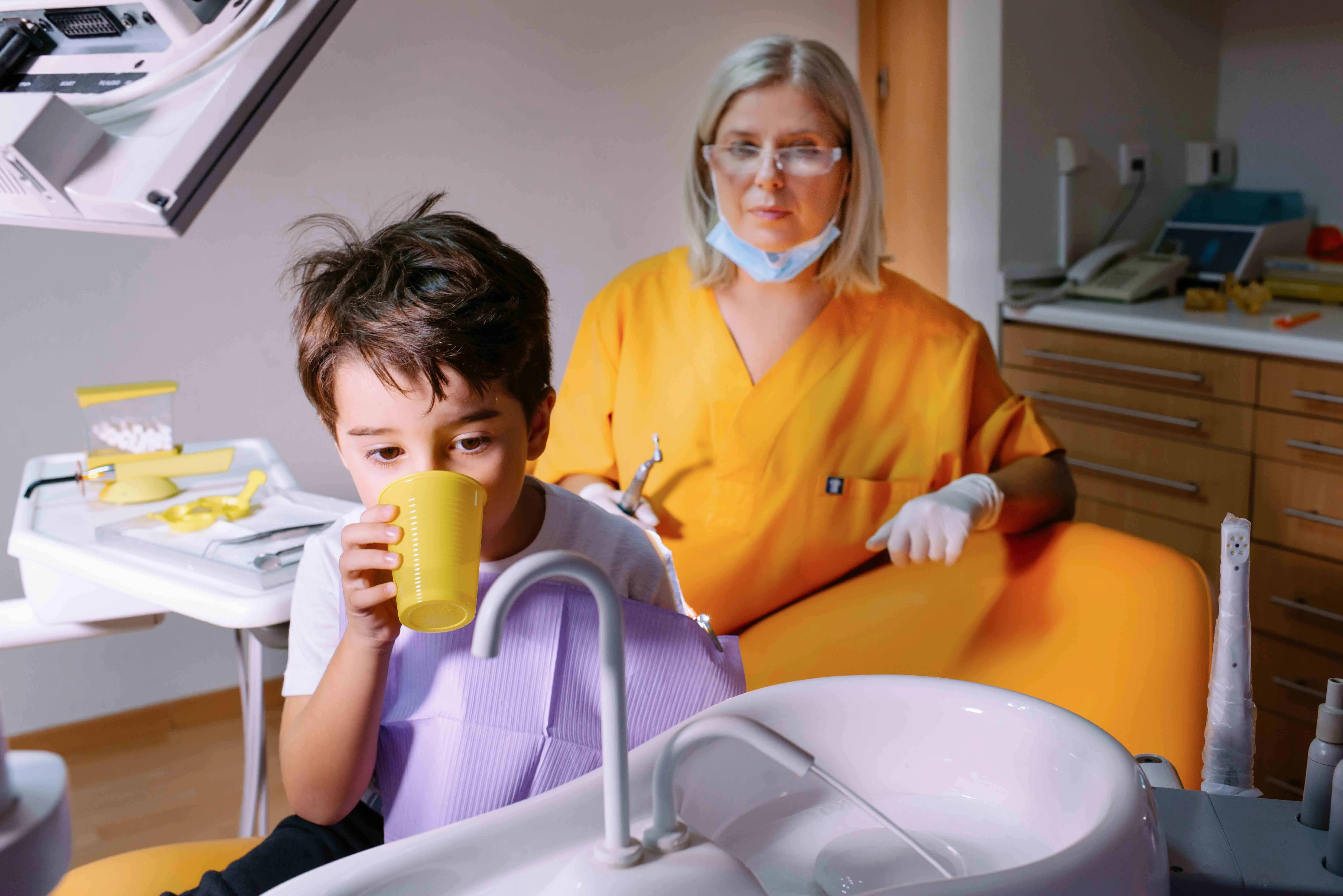 Παιδοδοντίατρος που εξηγεί τη διαδικασία σε παιδί